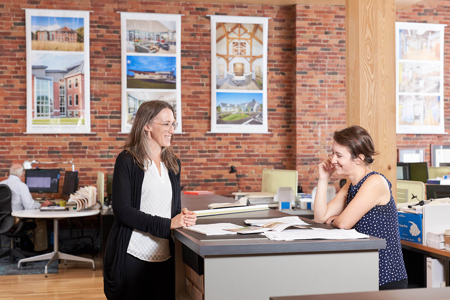 two women looking over some paperwork at a standing table